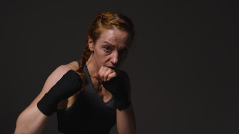 Studio-Portrait-Of-Mature-Woman-Wearing-Gym-Fitness-Clothing-Exercising-Sparring-At-Camera-5